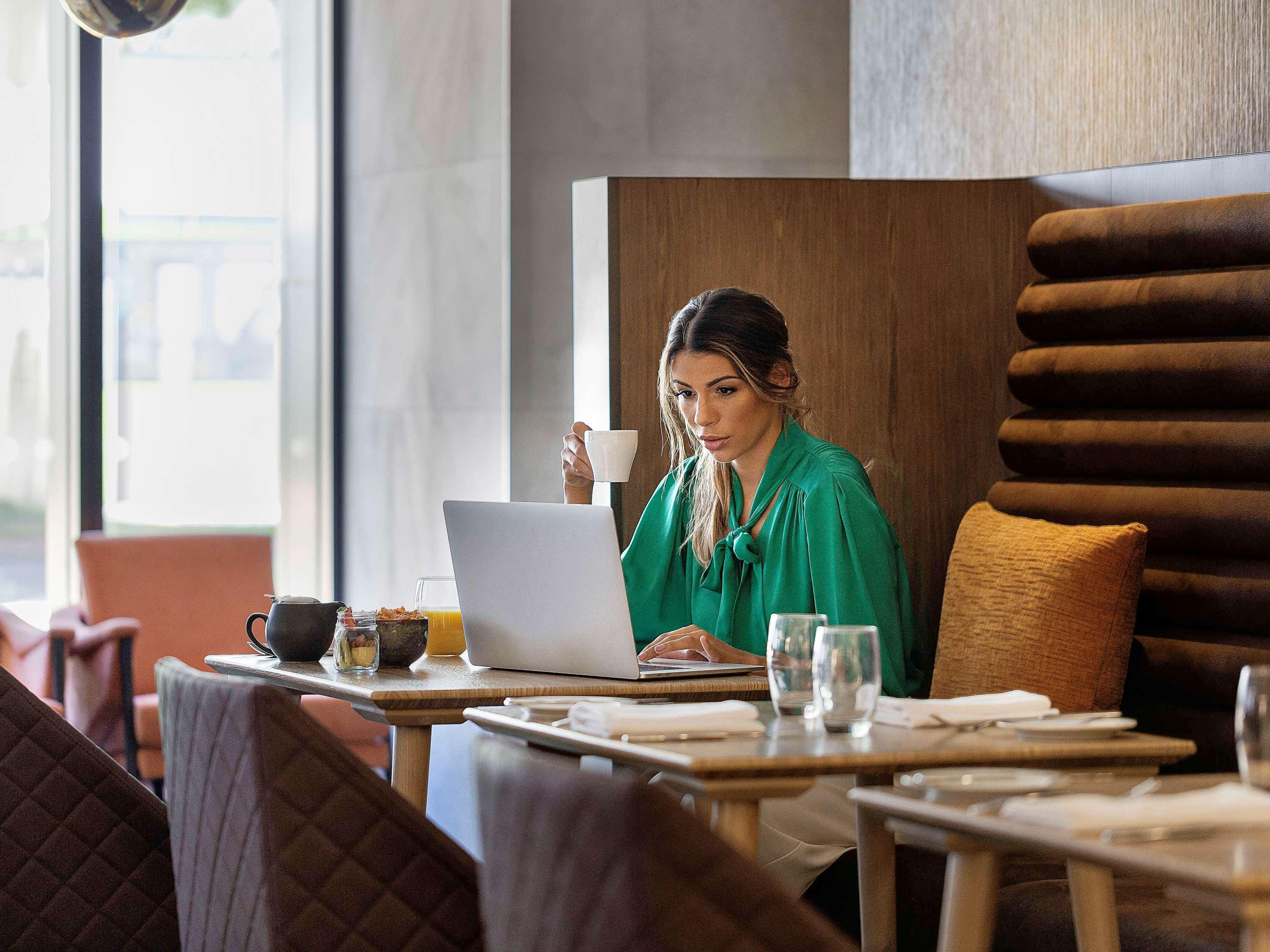 Hotel Pullman Distretto di Rotorua Esterno foto A woman working on a laptop